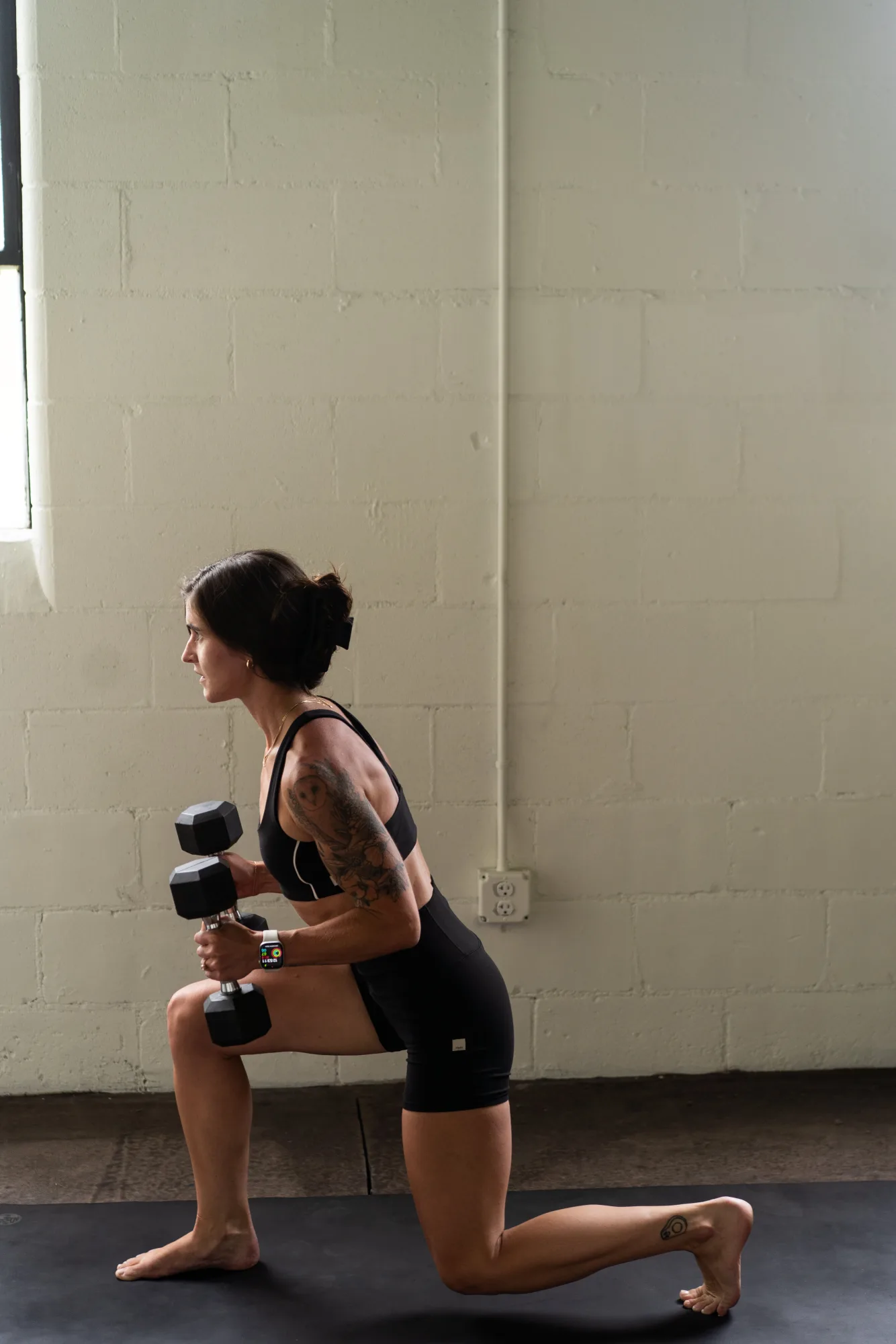 Kneeling dumbbell lunge at a Studio III class